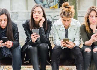 Group,Of,Girls,Using,Cellphones,On,Park,Bench.,Technology,Smartphones